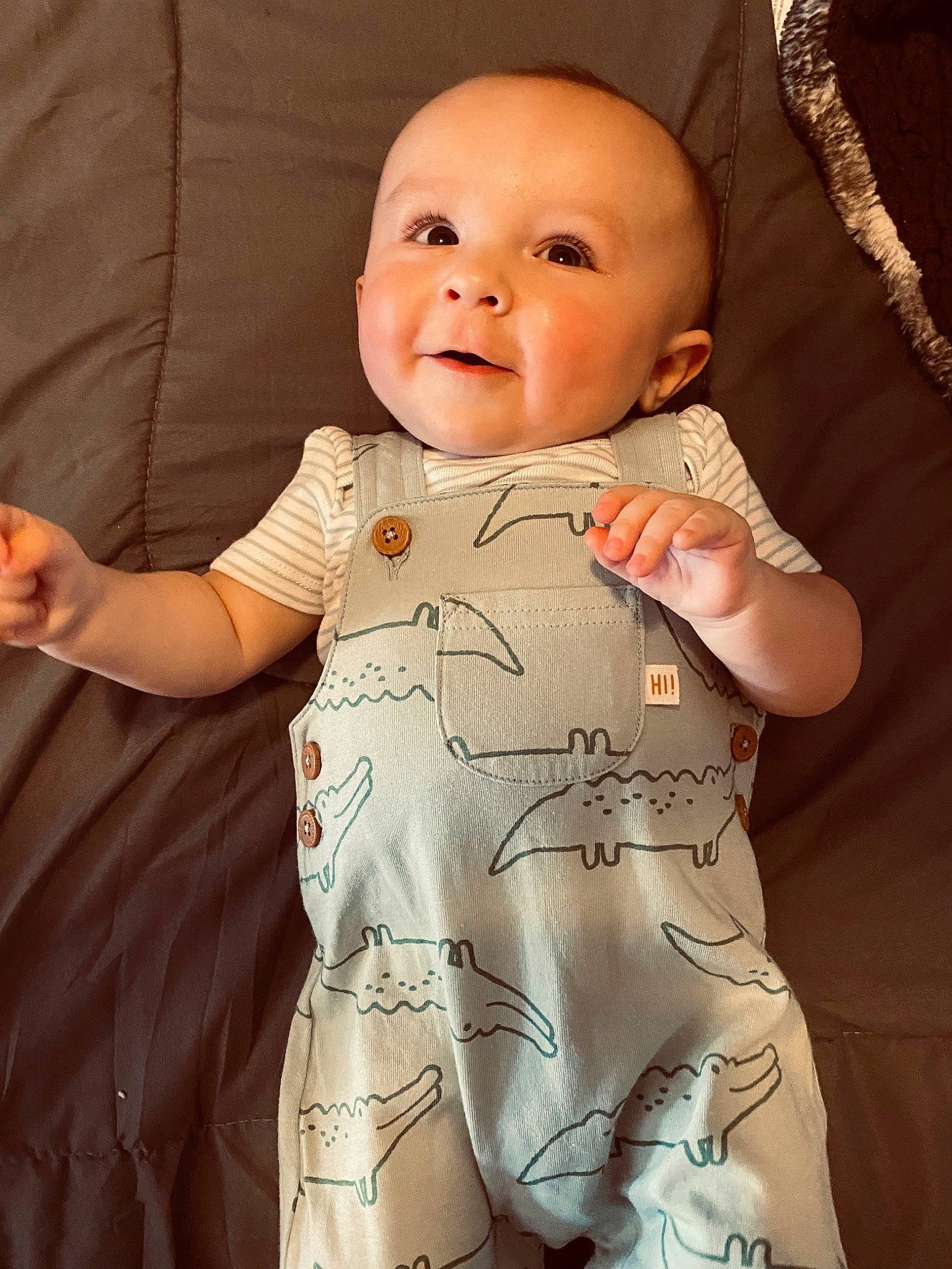 Landen is registered to the contest to win money with this photo: baby, baby_toddler_clothing, cheek, comfort, face, facial_expression, finger, gesture, iris, lip, neck, nose, outerwear, person, product, skin, sleeve, smile, standing, stomach