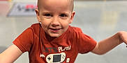 Logan a rejoint le concours — aidez-le/la à gagner de superbes lots ! child, boy, smile, tshirt, shorts, indoor, play_area, happy, portrait, casual_clothing, short_hair, young, fun, playful, standing, arms_outstretched, colorful_background, floor, person, kid