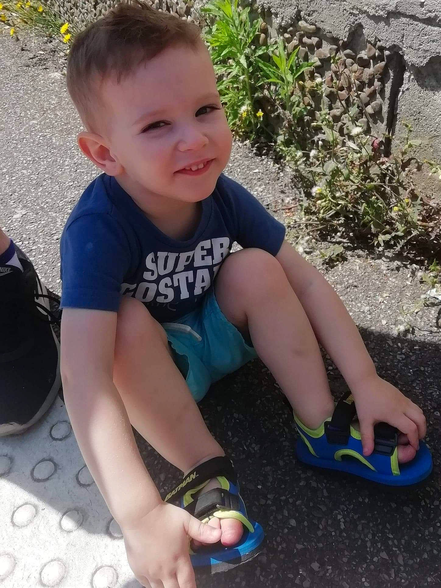Noah participe au concours pour gagner de l'argent avec cette photo : child, cool, foot, footwear, grass, human_leg, leg, person, play, shoe, sitting, smile, summer, thigh, toddler, toe, vacation