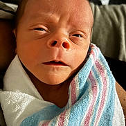 Theo joined the competition — help win amazing prizes! baby, blanket, child, closeup, cute, expression, face, head, hospital_blanket, human, indoors, infant, newborn, person, portrait, skin, sleepy, soft, swaddled, wrapped