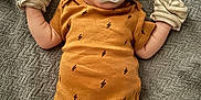 Theo is registered to the contest to win money with this photo: baby, blanket, clothing, cute, face, head, indoor, infant, lying_down, mittens, newborn, onesie, pacifier, pattern, person, resting, sleepwear, small, soft_texture, striped