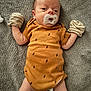 Theo is registered to the contest to win money with this photo: baby, infant, pacifier, mittens, onesie, clothing, blanket, lying_down, face, head, person, newborn, cute, sleepwear, pattern, striped, soft_texture, indoor, resting, small