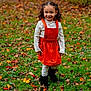 child, girl, smiling, curly_hair, orange_dress, pinafore, tights, boots, grass, autumn, leaves, outdoor, nature, fall, happy, portrait, young, standing, daylight, cute