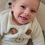 baby, smiling, infant, child, cozy_clothing, bear_theme, plush, cushion, soft_texture, cute, happy, indoor, portrait, sitting, fuzzy, clothing, face, head, eyes, hand