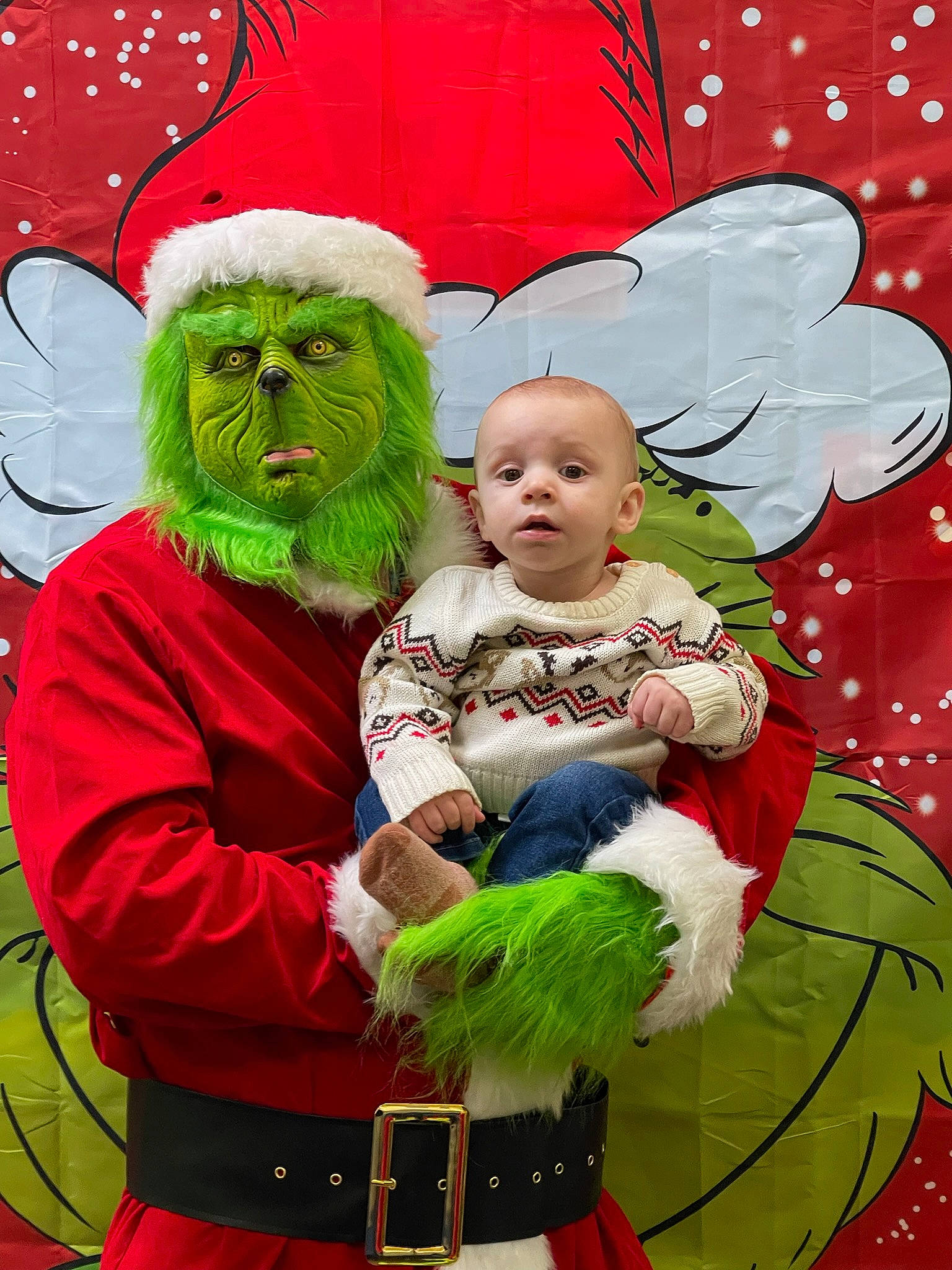Micah is registered to the contest to win money with this photo: baby, child, christmas, christmas_eve, costume, costume_design, costume_hat, event, fictional_character, fur, green, happy, hat, holiday, ornament, person, red, santa_claus, supernatural_creature, surprise