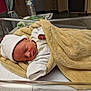newborn, baby, infant, sleeping, blanket, hospital, bassinet, hat, white_clothing, towel, resting, indoors, peaceful, young_child, bed, soft_texture, medical_setting, person, cute, sleep