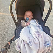 Bryan a rejoint le concours — aidez-le/la à gagner de superbes lots ! baby, babywear, blanket, carriage, child, clothing, cozy, cute, expression, handlebar, infant, outdoor, pacifier, person, portrait, seat, stroller, sunlight, toddler, wheel