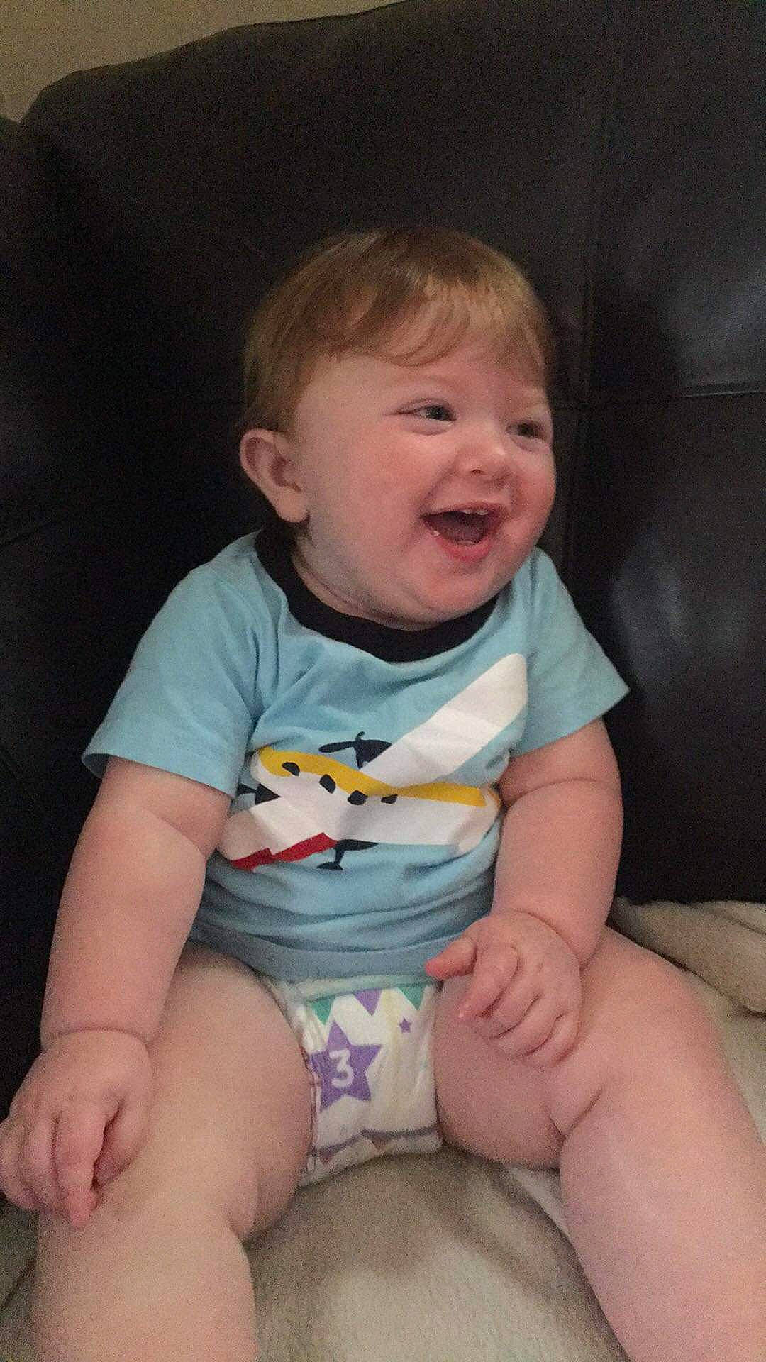 Kason is registered to the contest to win money with this photo: arm, baby, baby_products, baby_toddler_clothing, cheek, child, chin, facial_expression, finger, fun, hand, leg, lip, mouth, person, product, sitting, skin, smile, thumb