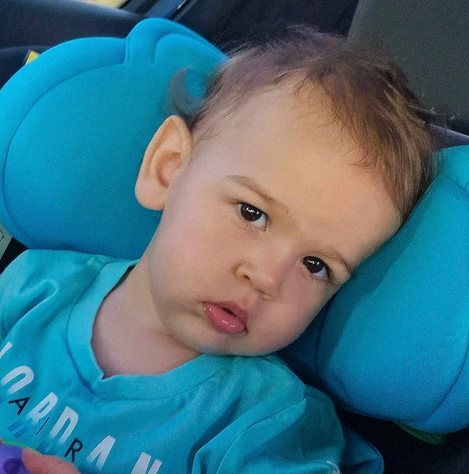 Kevin is registered to the contest to win money with this photo: toddler, child, face, closeup, car_seat, blue, cushion, curious, expression, young_child, indoors, clothing, person, portrait, head, hair, skin, eye, casual, seat