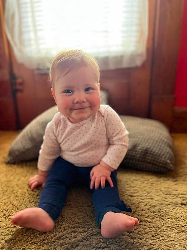 Charlee is registered to the contest to win money with this photo: baby, baby_toddler_clothing, cheek, child, chin, comfort, eye, face, facial_expression, floor, flooring, hairstyle, happy, head, iris, joy, person, skin, sleeve, smile