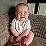 baby, child, smile, toy, armchair, corduroy, indoors, cute, happy, person, infant, skin, clothing, feet, furniture, face, hands, seated, door, home