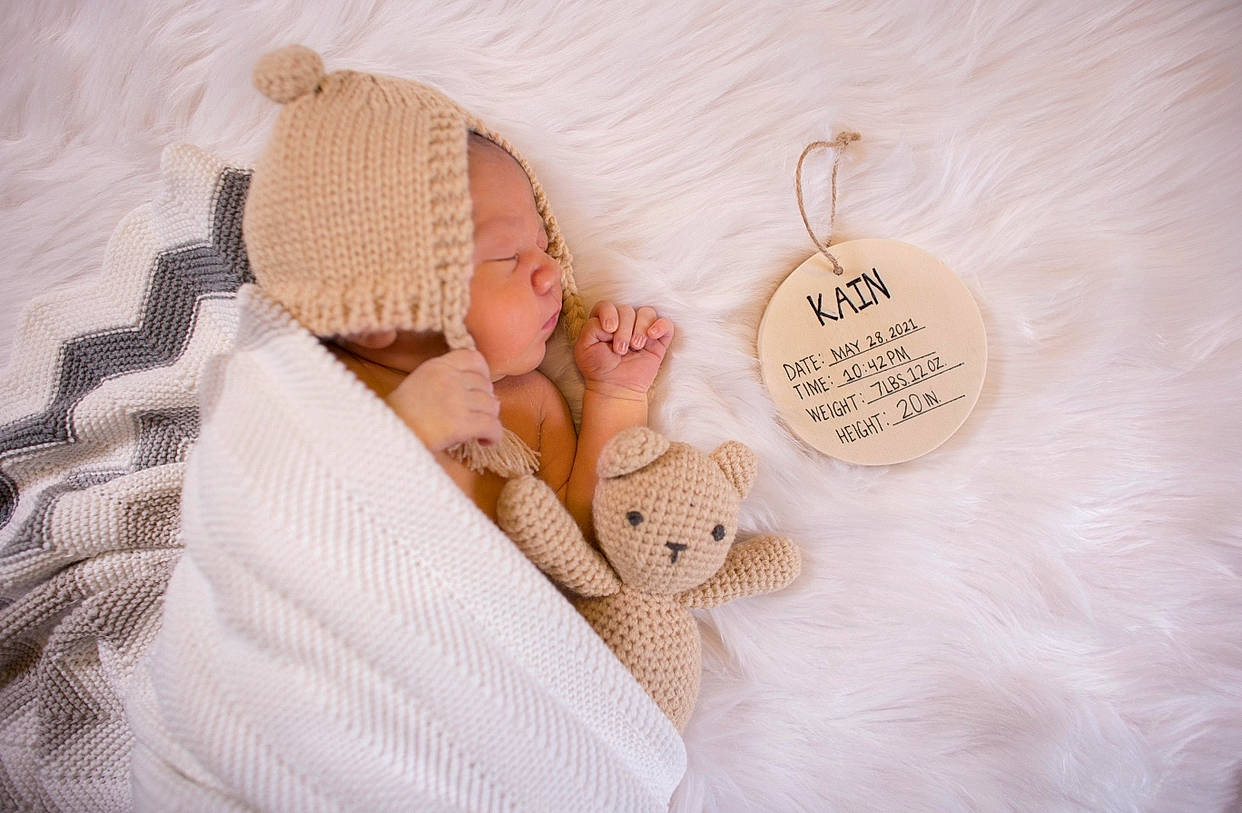 Kain is registered to the contest to win money with this photo: art, baby, baby_sleeping, baby_toddler_clothing, bedding, child, comfort, craft, fashion_accessory, finger, foot, hand, headgear, linens, nail, pattern, peach, person, toddler, wood