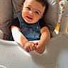 Naïm a rejoint le concours — aidez-le/la à gagner de superbes lots ! toddler, child, high_chair, smiling, indoor, curly_hair, denim_overalls, happy, baby, feeding, tray, seat, cute, infant, person, young_child, portrait, sunlight, playful, messy