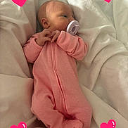Delilah is registered to the contest to win money with this photo: baby, newborn, pacifier, pink_onesie, sleeping, blanket, white_bedding, heart_graphics, infant, cute, soft_lighting, portrait, resting, cozy, tiny_hands, small_feet, indoors, child, peaceful, wrapped