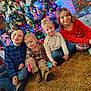 carpet, casual_clothing, celebration, child, children, christmas_tree, colorful, decorations, family, festive, happy, holiday, home, indoor, portrait, presents, sitting, smiling, toddler, toys