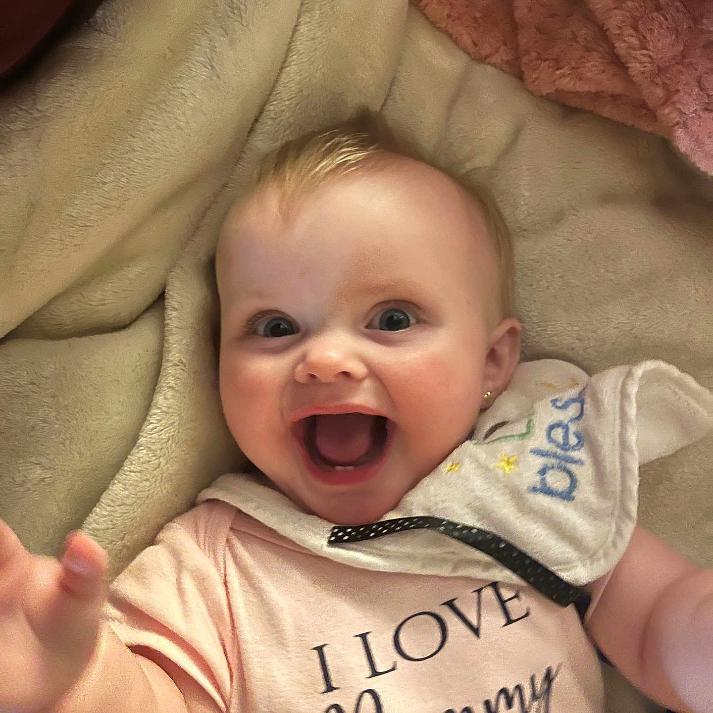 Addison is registered to the contest to win money with this photo: baby, babylaughing, bed, bodypart, clothing, face, finger, furniture, hand, happy, head, laughing, mouth, newborn, person, photography, portrait, quilt, smile, t_shirt