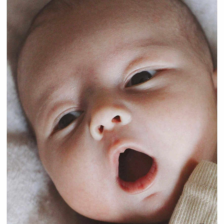 Izac participe au concours pour gagner de l'argent avec cette photo : baby, blanket, close_up, clothing, comfort, cute, expression, eyes, face, head, indoors, infant, lying_down, newborn, open_mouth, portrait, skin, sleepwear, soft, young_child