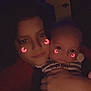 Aaron is registered to the contest to win money with this photo: person, baby, face, glowing_filter, crescent_moon, cheek_decor, striped_clothing, holding, indoor, dim_light, purple_light, selfie, closeup, smile, cute, warm, portrait, child, family, nighttime