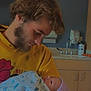 Aaron is registered to the contest to win money with this photo: newborn, baby, man, holding, hospital, indoors, blanket, hat, tender, care, parent, child, person, face, yellow_hoodie, cabinet, sink, medical, room, portrait