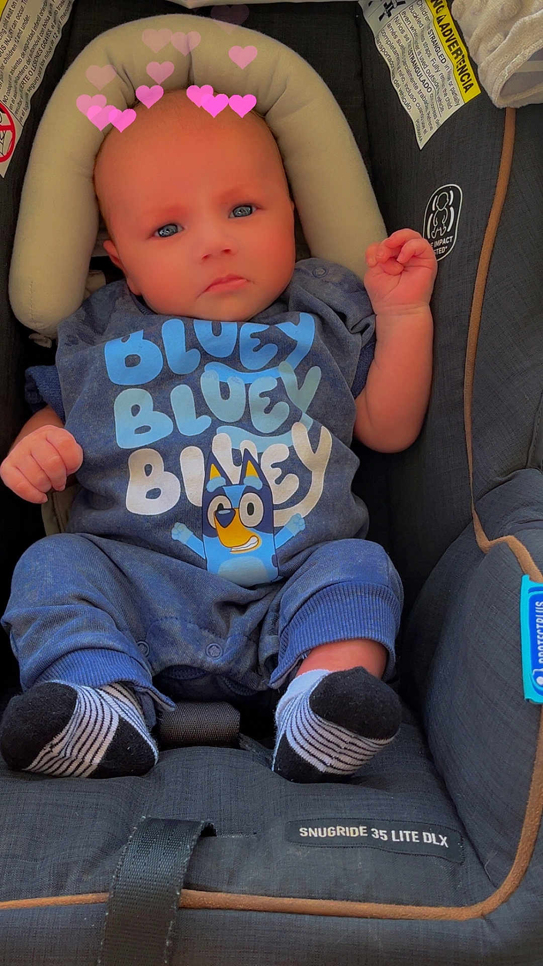 Aaron is registered to the contest to win money with this photo: baby, infant, child, car_seat, bluey, clothing, socks, heart_emoji, pink_heart, baby_outfit, seatbelt, snugride, cute, portrait, indoor, closeup, person, head, face, expression