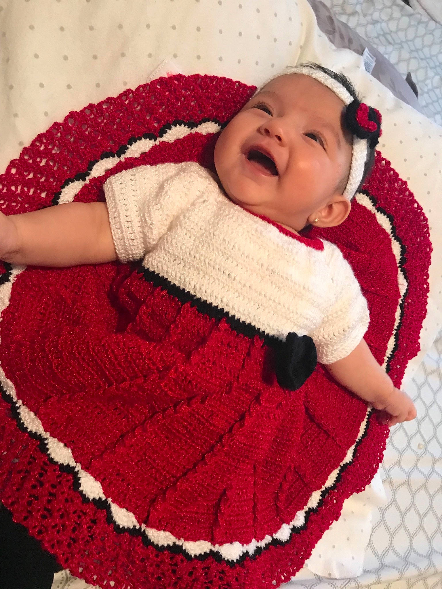 Keilany is registered to the contest to win money with this photo: art, baby, baby_products, child, crochet, headwear, knitting, outerwear, pattern, person, product, red, smile, textile, toddler, wool, woolen