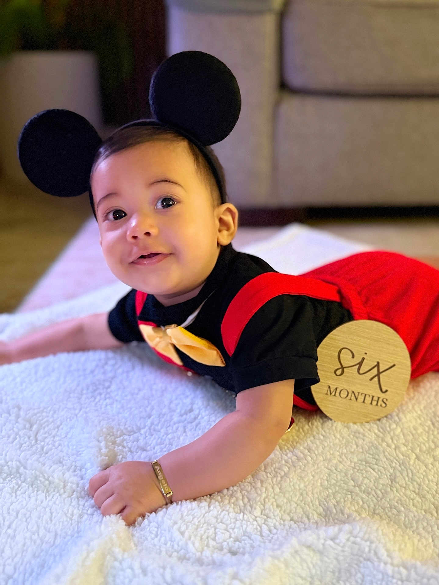 Angelo Hernandez joined the competition — help win amazing prizes! baby, infant, child, costume, mouse_ears, red_clothing, black_clothing, bow_tie, bracelet, blanket, cute, smile, face, lying_down, indoors, soft_texture, six_months, baby_milestone, portrait, playful