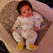 Keziah is registered to the contest to win money with this photo: baby, infant, onesie, socks, bee_pattern, seat, cushion, indoor, child, cute, smile, face, person, clothing, fabric, soft, relaxing, small, comfort, happy