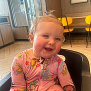 Leah Rose is registered to the contest to win money with this photo: toddler, child, smile, pajamas, princess, indoor, high_chair, yellow_chair, wood_floor, window, door, happy, face, hair, cute, seat, person, clothing, baby, playful