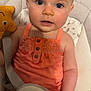 Délya a rejoint le concours — aidez-le/la à gagner de superbes lots ! baby, baby_seat, blue_eyes, child, coral_dress, curious, cushion, earrings, face, hair, hand, indoor, infant, person, portrait, sitting, skin, smile, star_toy, toy