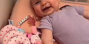 Délya a rejoint le concours — aidez-le/la à gagner de superbes lots ! arm, baby, cheerful, child, crib, cute, earring, face, happy, indoor, infant, onesie, person, pink, playtime, purple, smile, soft_toys, star_pattern, toy
