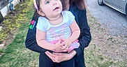 Josephine is registered to the contest to win money with this photo: toddler, child, woman, outdoor, backyard, grass, car, bunny_ears, headband, smile, holding, person, casual_clothing, daylight, nature, happy, family, portrait, shoe, playful