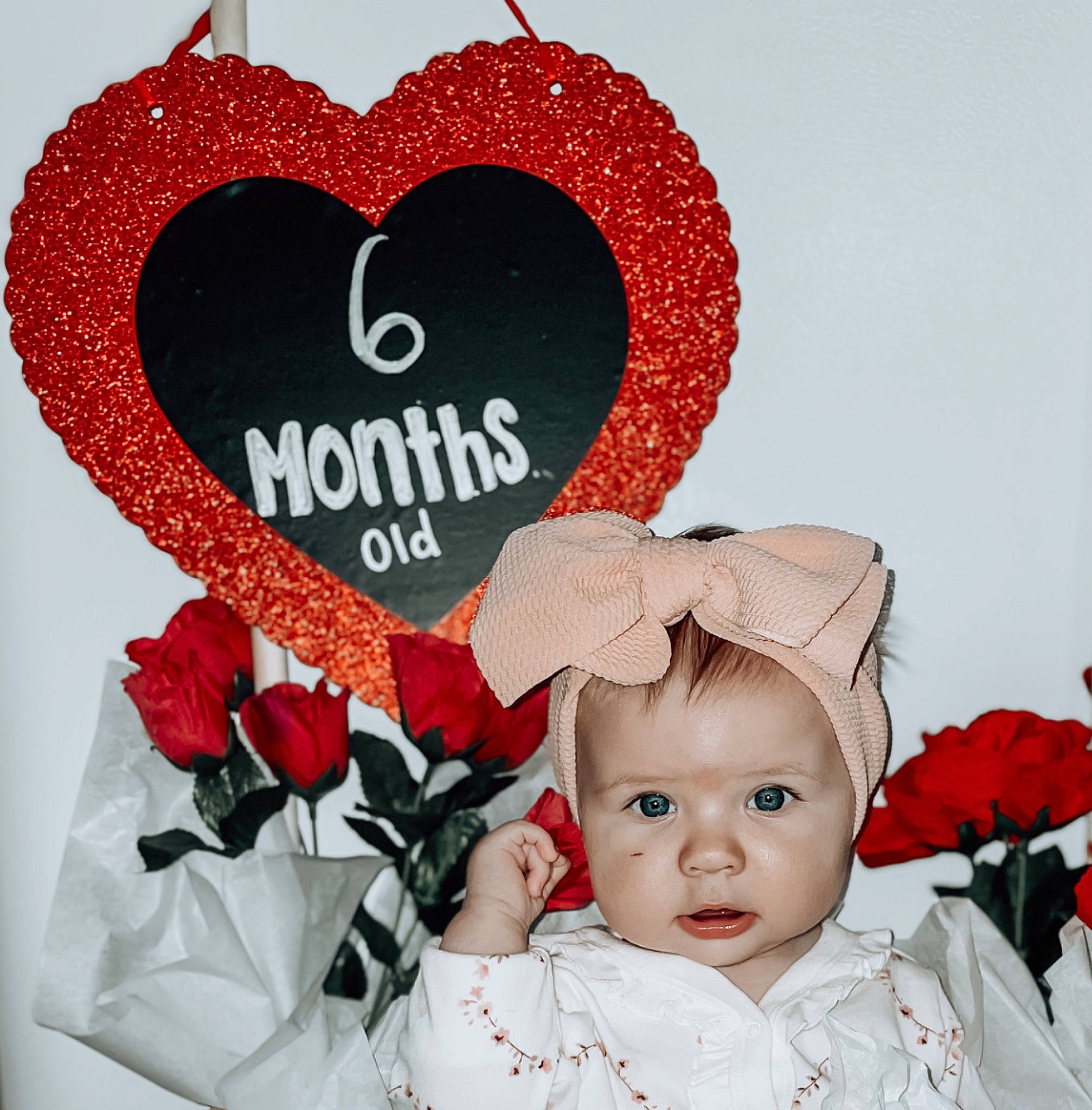 Ellianna is registered to the contest to win money with this photo: baby, baby_toddler_clothing, beauty, cut_flowers, event, facial_expression, flower, flower_arranging, font, happy, headpiece, lip, organ, person, petal, pink, plant, red, rose, toddler