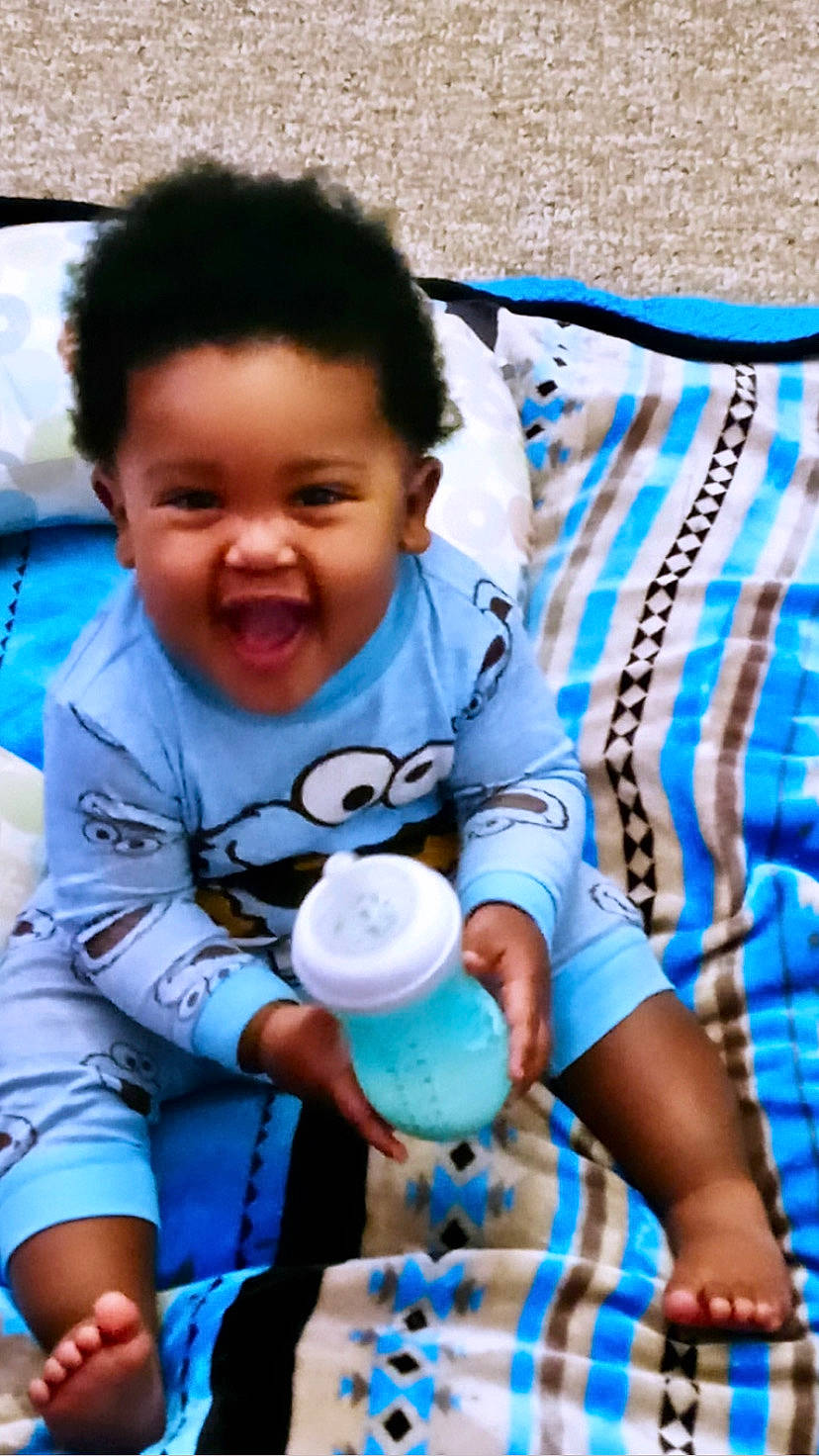 Coby is registered to the contest to win money with this photo: azure, baby, baby_toddler_clothing, blue, cool, facial_expression, finger, fun, happy, mammal, organ, person, photograph, product, skin, sleeve, smile, summer, t_shirt, toddler