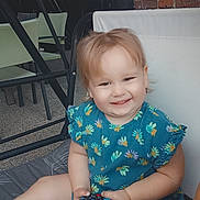 Livia participe au concours pour gagner de l'argent avec cette photo : toddler, child, smiling, blue_dress, puzzle_cube, sitting, cushion, indoor, face, expression, happy, short_hair, sock, toy, person, furniture, patterned_clothing, legs, hand, playful