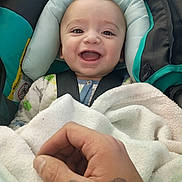 Isaiyel Gurule joined the competition — help win amazing prizes! baby, smiling, car_seat, blanket, hand, tattoo, child, infant, clothing, person, happy, face, portrait, indoor, cute, young_child, seatbelt, closeup, baby_clothes, comfort