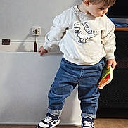 Charlie participe au concours pour gagner de l'argent avec cette photo : blond_hair, book, boy, cabinet, casual_clothing, child, cute, dinosaur_print, electric_socket, hands, indoor, jeans, looking_down, playtime, portrait, sneakers, standing, toddler, white_sweatshirt, wooden_floor