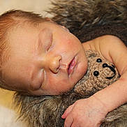 Clayton is registered to the contest to win money with this photo: newborn, baby, sleeping, portrait, face, closed_eyes, peaceful, teddy_bear, blanket, furry_blanket, cuddling, infant, head, arms, skin, indoors, closeup, cozy, soft_lighting, resting