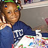 Kalise joined the competition — help win amazing prizes! child, birthday, cake, birthday_cake, number_five, smiling, peace_sign, portrait, indoors, party, celebration, colorful, hair_beads, braids, blue_shirt, table, frosting, candles, cake_decorations, happy