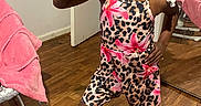 Musik is registered to the contest to win money with this photo: child, girl, smile, peace_sign, leopard_print, floral_pattern, beaded_hair, white_socks, wooden_floor, mirror, pink_towel, indoor, door, furniture, happy, pose, clothing, person, portrait, home