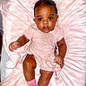 baby, child, pink_clothing, pink_socks, blanket, bows, pacifier, infant, cute, sitting, indoor, portrait, soft_texture, young_child, face, looking_at_camera, adorable, closeup, baby_girl, comfortable