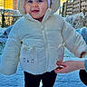 baby, child, snow, winter, jacket, hood, cute, smiling, outdoor, footwear, hand, fence, house, sunlight, blue_sky, cold, warm_clothing, person, standing, support