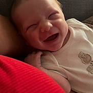 Jayden a rejoint le concours — aidez-le/la à gagner de superbes lots ! baby, smiling, infant, person, clothing, red_shirt, couch, texture, face, happy, closeup, human, casual, home, relaxation, comfort, expression, joy, skin, sleeveless