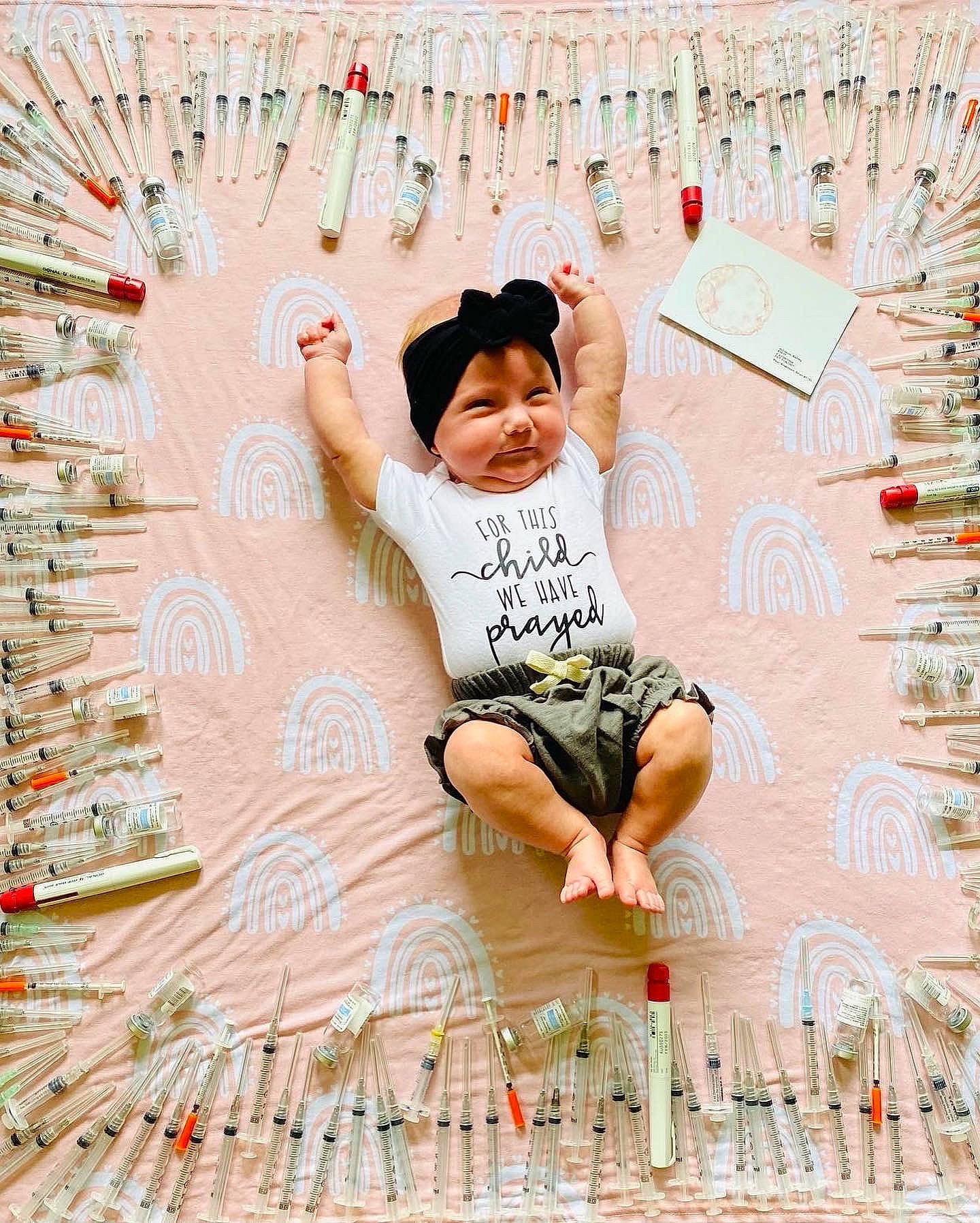 Jayla is registered to the contest to win money with this photo: arm, baby, child, facial_expression, flooring, font, foot, fun, happy, headwear, human_body, leisure, line, pattern, people, person, pink, shorts, sitting, smile