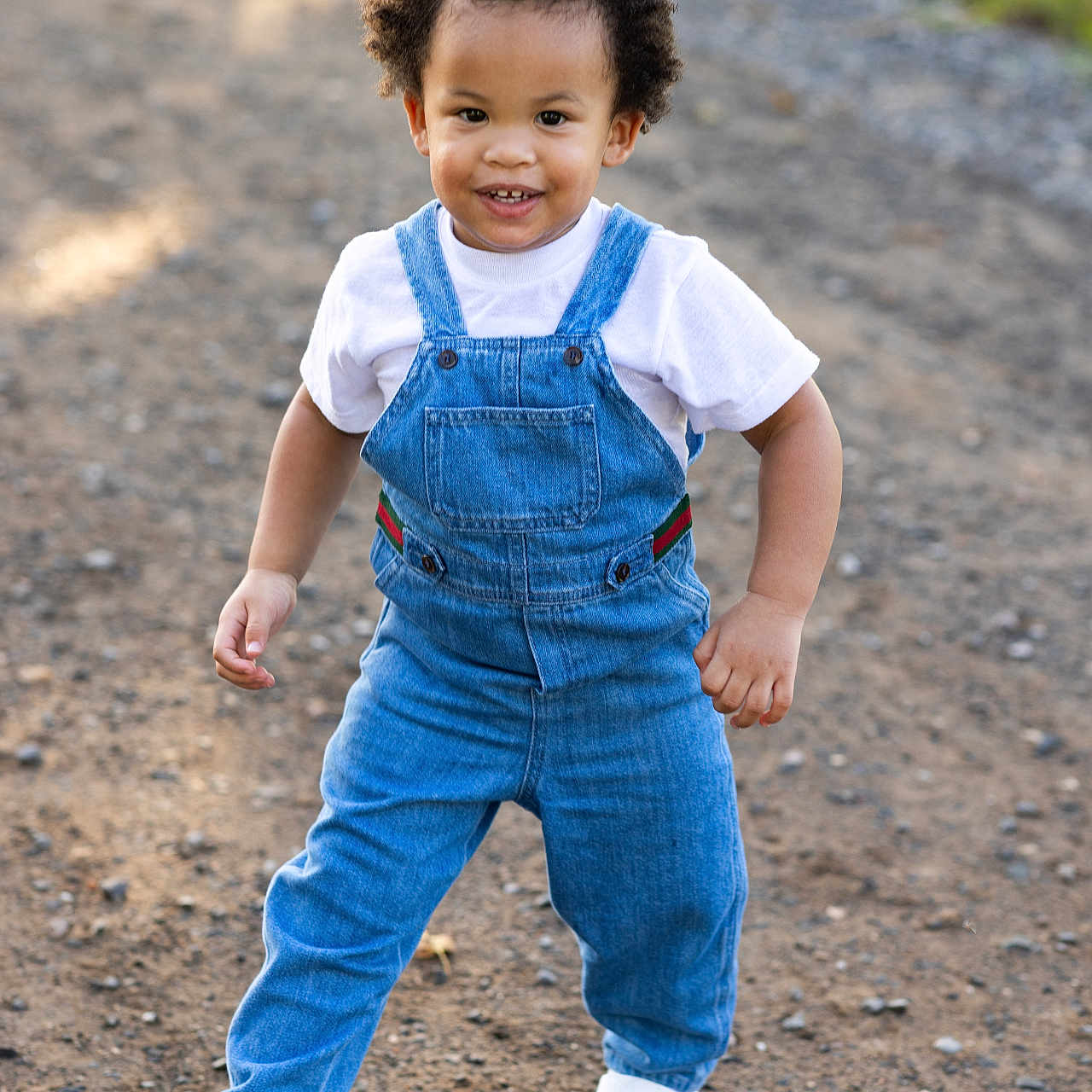 Maserati joined the competition — help win amazing prizes! casual_clothing, child, curly_hair, cute, daylight, denim_overalls, fashion, gravel_path, greenery, happy, nature, outdoor, person, portrait, smiling, sunlight, toddler, walking, white_shirt, white_sneakers