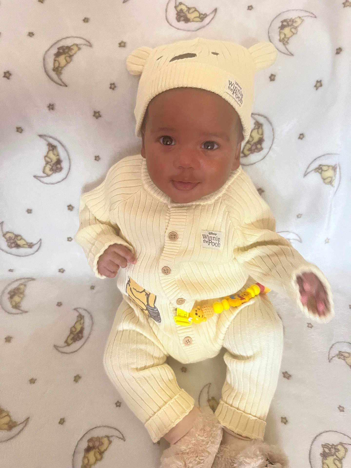 Malachi joined the competition — help win amazing prizes! baby, infant, child, winnie_the_pooh, knitted_clothing, hat, onesie, blanket, pattern, stars, moon, soft_toys, footwear, cute, smiling, portrait, indoors, cozy, seated, looking_at_camera