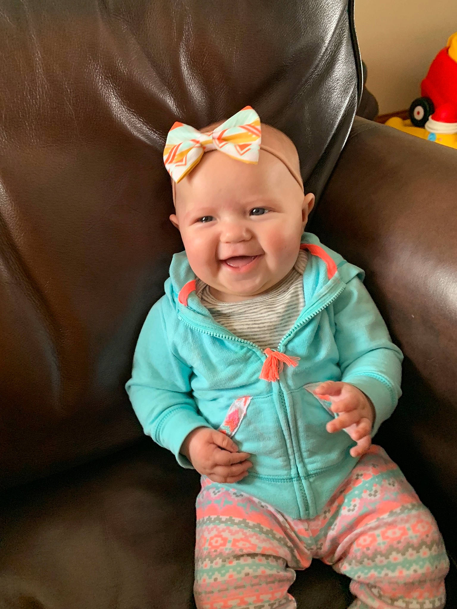 Penelope is registered to the contest to win money with this photo: baby, baby_toddler_clothing, cheek, child, ear, eye, face, hair_accessory, happy, head, headgear, joy, lip, organ, person, pink, play, sitting, skin, sleeve