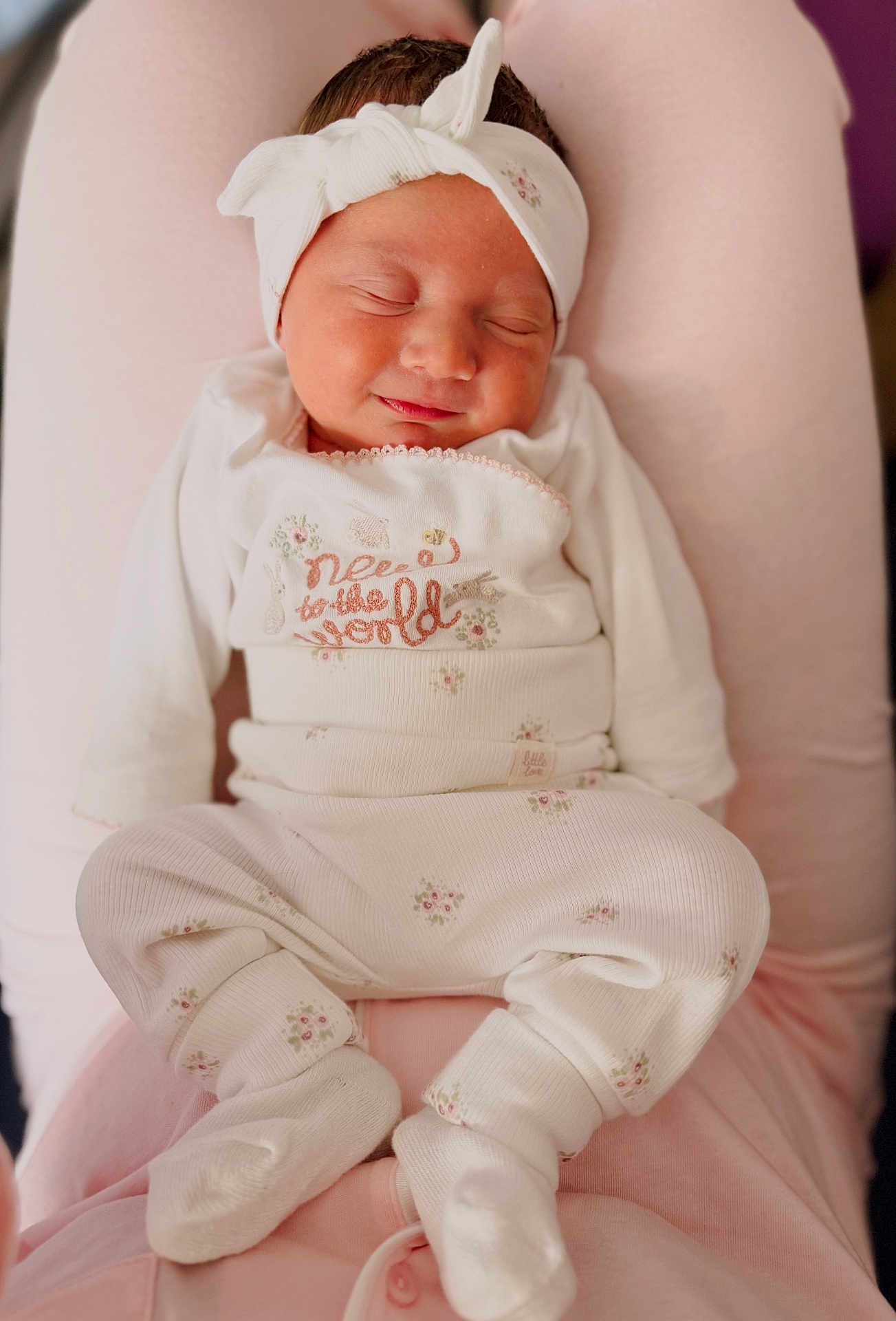 Billy-Ellen is registered to the contest to win money with this photo: newborn, baby, sleeping, headband, white_clothing, floral_pattern, infant, soft_texture, pink_background, cozy, cute, peaceful, resting, child, portrait, closeup, indoors, warm, comfort, adorable