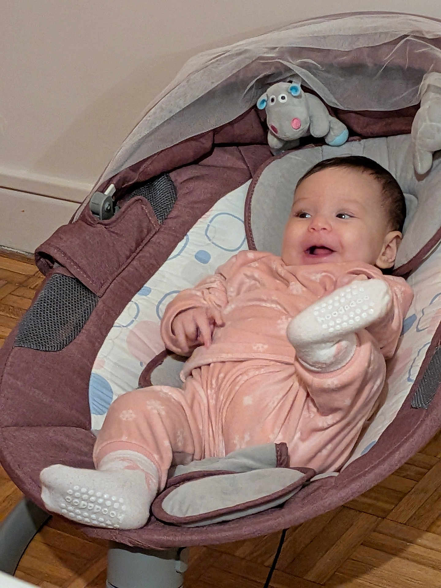 Sofia a rejoint le concours — aidez-le/la à gagner de superbes lots ! baby, infant, baby_rocker, pajamas, socks, stuffed_toy, hippo, smiling, happy, indoor, floor, wooden_floor, baby_clothes, child, cute, playful, relaxing, comfort, seat, person