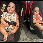 Asiel And Adriel is registered to the contest to win money with this photo: baby, toddler, car_seat, child, indoor, floor, clothing, patterned_shirt, footwearless, smiling, sitting, person, cute, matching_outfits, infant, seat_belt, car_seat_strap, carpet, wood_flooring, happy