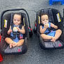 baby, car_seat, cupcake, frosting, outdoor, pavement, blue_clothing, child, messy, cute, toddler, footwear, seatbelt, playful, two_children, food, happy, summertime, plastic_chair, sitting